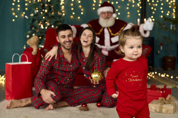 santa and young family at home playing with little baby child