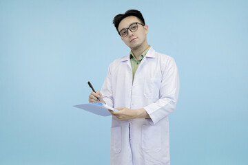 Confident Asian scientist or doctor in a lab coat and glasses, standing and  writing notes on a...