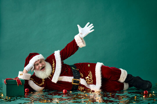A portrait of Santa Claus lying with golden confetti on a green background