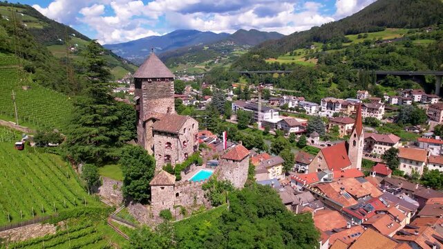  Italy. Charming village Chiusa  with medieval castle and abbey  Sabiona surrounded by Dolomites alps mountains. south Tyrol, Valle Isarco, in Trentino Alto Adige. aerial drone 4k hd footage