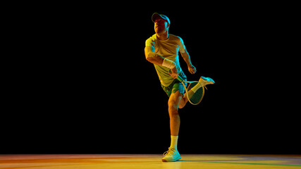 Concentrated tennis player lunging forward in full dynamic stretch for ball. Concept of health and wellness, physical activity awareness, body alignment, and fitness balance.
