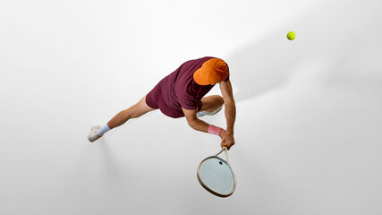 Tennis player in burgundy outfit stretching forward to return shot seen from above. Concept of education imagery, focus learning, discipline training, and skill development.