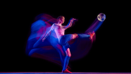 Fototapeta premium Female soccer player striking ball in motion blur with neon trail. Concept of sport campaign visuals, motion design, fitness advertising, and coaching materials.