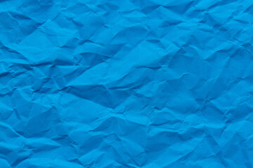 Obraz premium Close-up macro crumpled blue paper background,Abstract blue paper texture as background. Texture of slightly crumpled craft paper. Paper background. Recycled blue paper backdrop in close up.