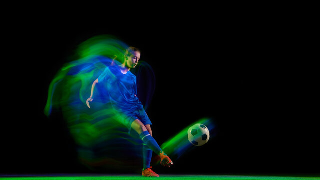 Female soccer player running with glowing orange and violet light trail. Concept of high-energy sport promotion, performance advertising, and fitness motivation visuals. - Powered by Adobe