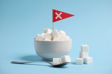 Sugar cubes in bowl with warning flag concept of health risk sugar intake