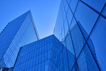 Futuristic blue glass high-rise skyscrapers facade. Low-angle view of modern corporate office buildings in a financial district. Business, finance, and contemporary architecture concept photo