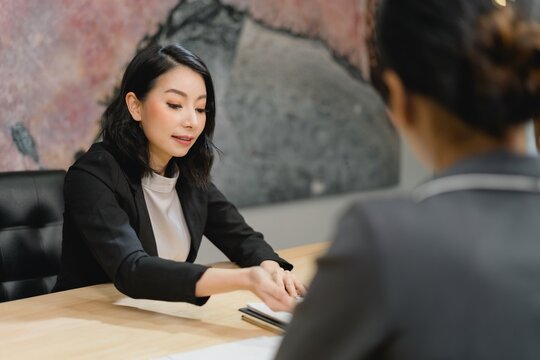 Professional woman confidently submitting critical documents or application materials during a formal interview or client information exchange