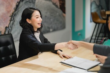Smiling professional woman shaking hands for successful job interview hiring, client acquisition, and final business agreement closure