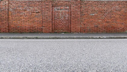 Mossy grunge brick wall at the roadside. Gray tiled sidewalk and street in front. Background for copy space.