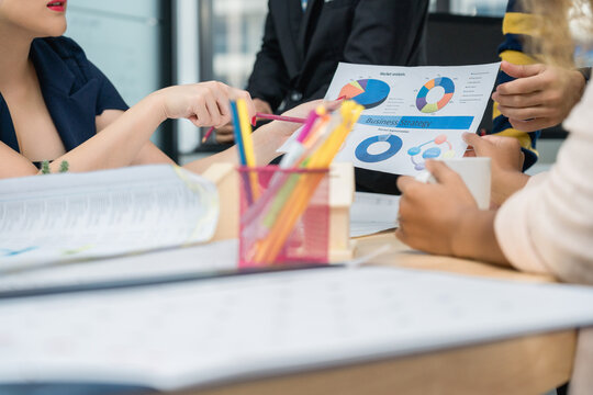 Close-up of diverse business team hands analyzing financial pie