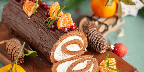 Yule log roll cake with chocolate ganache  on Christmas decorated background