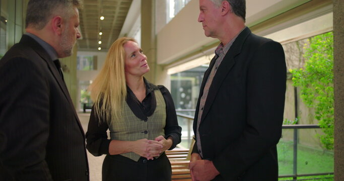 Confident female colleague presenting team members with handshake in office hallway, business professionals meeting during formal workplace introduction - Powered by Adobe