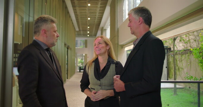 Confident female colleague presenting team members with handshake in office hallway, business professionals meeting during formal workplace introduction