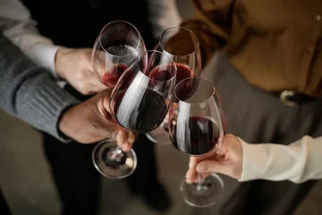 Acrylglasbilder Restaurant Diverse group of young adult and middle aged men and women clinking wine glasses during wine tasting, hands of multiethnic individuals holding glasses filled with red wine  © Seventyfour