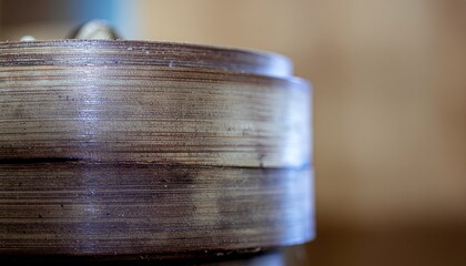 Close up of a textured wooden circular object with a glossy finish and shimmering particles against a softly blurred background