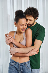Naklejka premium Cuddled close in their cozy home, a young couple shares a warm moment together