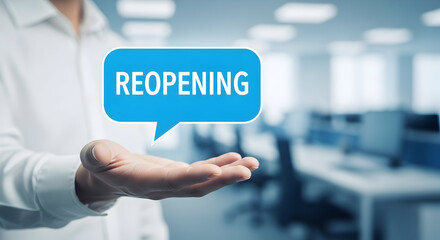 Hand holding a reopening message in a speech bubble against a blurred office background symbolizing business recovery and the return to work after restrictions are lifted promoting economic growth
