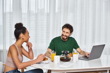 Young couple enjoys a cozy breakfast at home with warm drinks and shared smiles