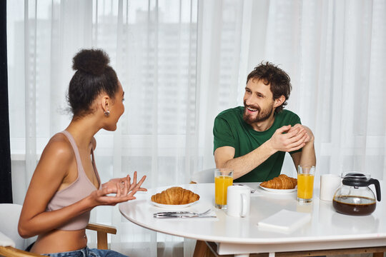 Cozy breakfast conversation between young couple at home with fresh pastries