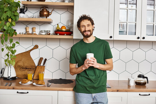 Cozy young man enjoys a peaceful morning in a bright and inviting kitchen space