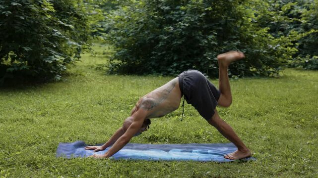 Man performing smooth mobility and roll transitions barefoot outdoors