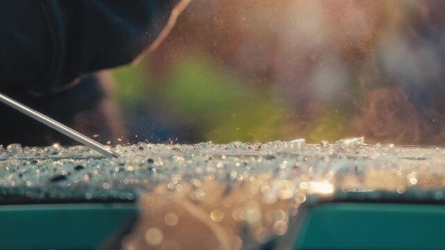 Scraping Broken Glass with Screwdriver Under Workshop Light
