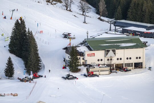Many snow groomers at the mountain station of the Hochbrixen gondola lift in winter, Skiwelt Wilder Kaiser Brixental, Tyrol, Austria