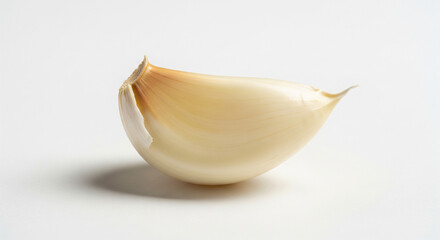 A single, whole, raw garlic clove (peeled) resting on a pure, seamless white background. Its smooth, translucent texture and subtle shine are highlighted by direct, soft lighting. Aromatic, pungent.
