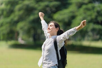Woman standing outdoors with arms raised and eyes closed, ecstatic joy, personal freedom, and massive goal achievement