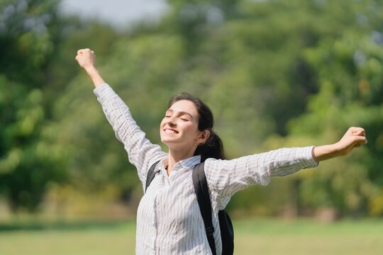 Woman standing outdoors with arms wide open, ecstatic joy, personal freedom, and embracing success and the future