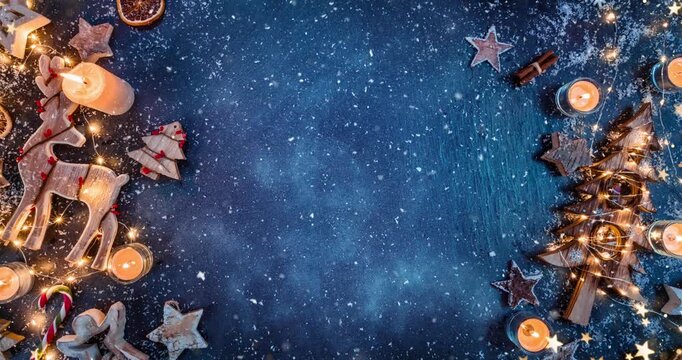 Cozy Christmas decorations arranged on dark black stone with gentle falling snow creating a festive winter atmosphere. Ideal as a holiday background or seasonal backdrop.