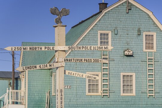 Distance sign in front of an old wooden house, Barrow, Alaska, USA