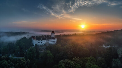 view of Konopiste Castle at sunrise in the fog