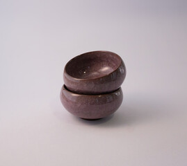 Stacked stone bowls on neutral studio background