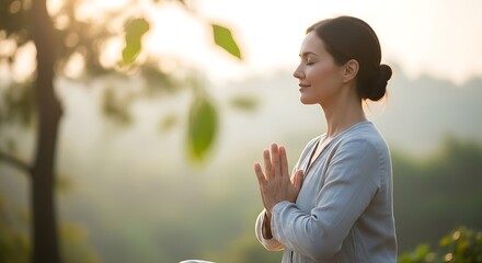 Woman meditating outdoors with hands together in prayer position
