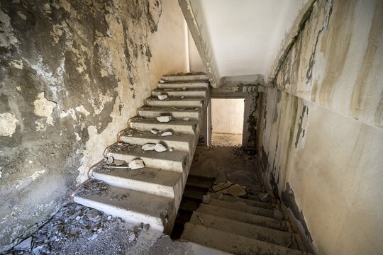 A crumbling staircase in an abandoned building with peeling paint and visible decay, ghost town, Engilchek, Tian Shan, Kyrgyzstan