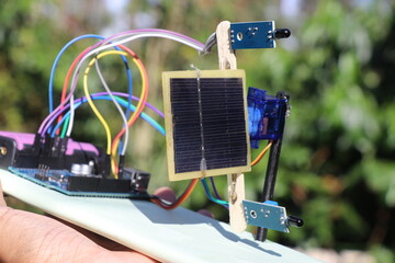 Automatic solar tracking prototype project with solar panel and infrared light sensors controlled by a microcontroller in the background