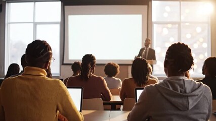 Back view of diverse audience listening to a speaker in a classroom 4k video - Powered by Adobe