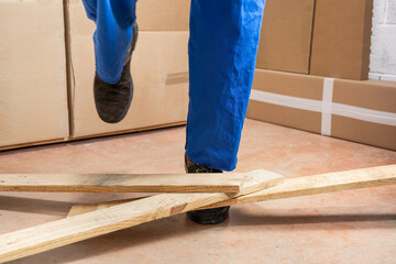 Close up of a construction worker stumbling with a cord in a warehouse