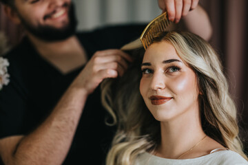Fototapeta premium A client in a hair studio receives a professional styling session, with a stylist brushing her blonde locks. The scene conveys beauty, care, and confidence in a modern salon setting.