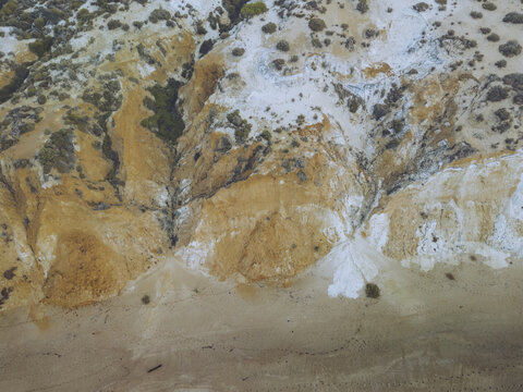 Aerial view of the Playa Torre del Loro's dramatic landscape, where ochre sands meet chalky cliffs, creating a stark contrast under the Spanish sun, Mazagon, Andalusia, Spain.
