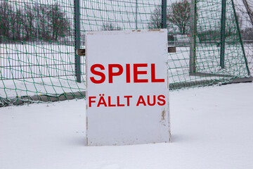Symbolbild Spielabsage im Fußball wegen Schnee. Schild auf einem Sportplatz mit der Aufschrift SPIEL FÄLLT AUS