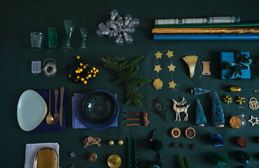 Christmas festive preparation concept flat lay on the green linen fabric. Xmas objects for table and tree decoration