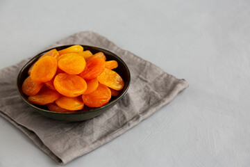 Organic Raw Dry Apricots in a Bowl, side view. Copy space.