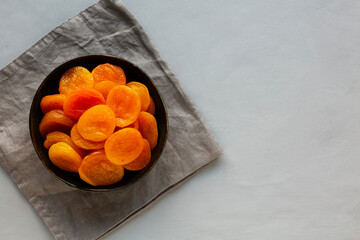 Organic Raw Dry Apricots in a Bowl, top view. Overhead, from above. Copy space.