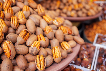 Pile of fresh pecans in their shells displayed on a market table, showcasing the rich textures and natural colors of the nuts, inviting culinary exploration and healthy snacking options