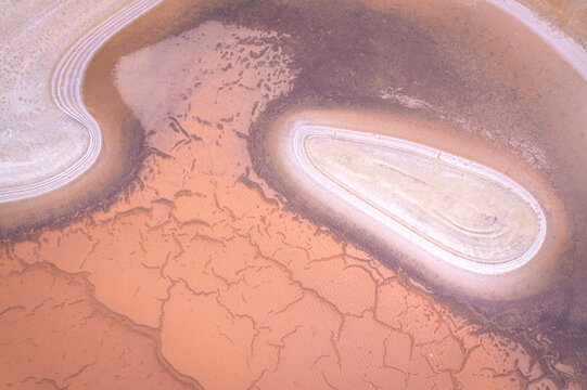 Aerial view of parched earth with cracked textures contrasting with winding pale waterways, a stark tableau of nature's artistry, West Ballidu, Western Australia, Australia.
