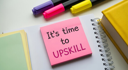 It s time to upskill message on pink sticky note with markers and books