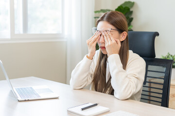 Eye problem concept, fatigue asian young woman tired eyes, irritated rubbing eye dry relief vision pain after work on laptop computer, eye strain, hand holding glasses, suffer migraine, bad blurry.